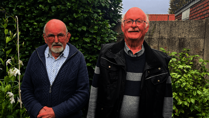 Toon en Arie staan naast elkaar in de achtertuin