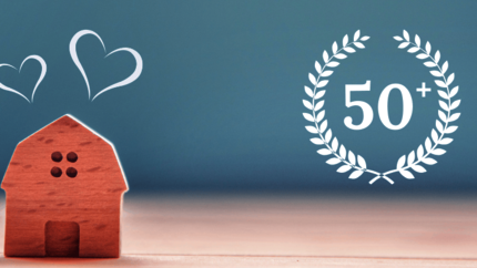 Afbeelding van een houten huisje met blauwe achtergrond en een 50 jubileum logo