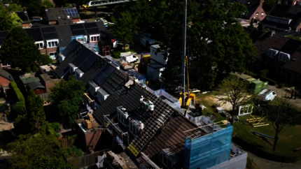 Drone shot van een blok woningen aan de Vlasakker tijdens werkzaamheden aan het dak