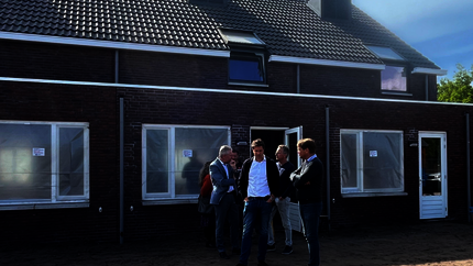 Burgemeester en enkele raadsleden voor de woningen in Bakel